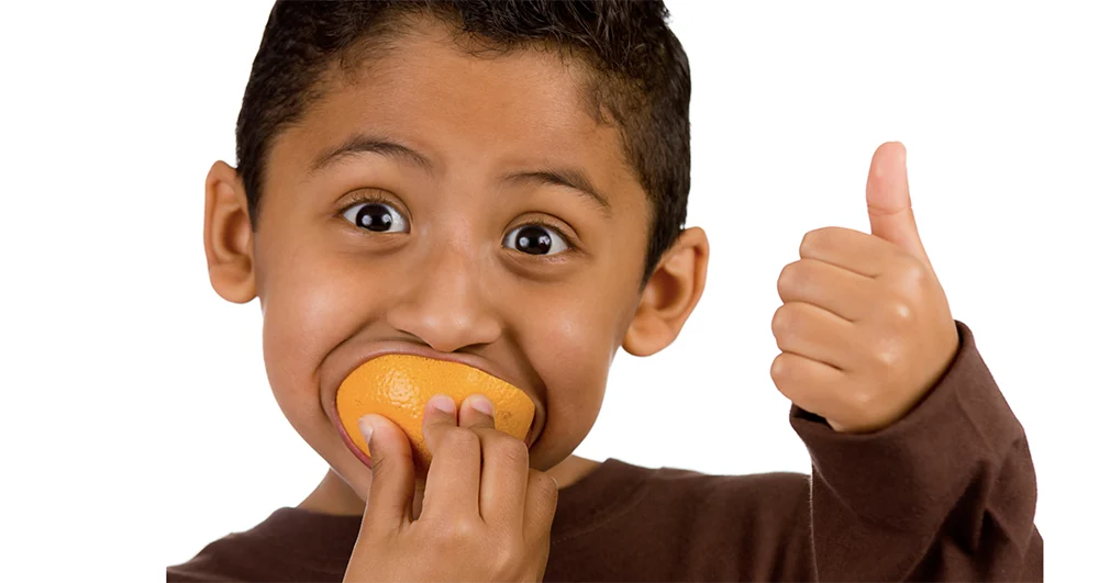 Kid eating an orange